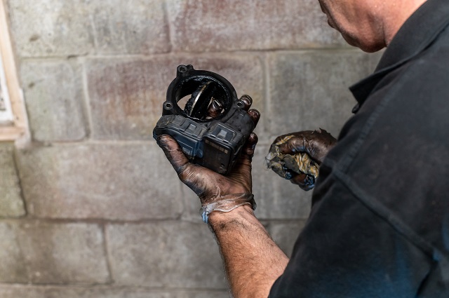 Mann untersucht AGR Ventil das klemmt | autoreparaturen.de