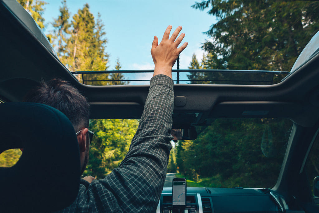 Autofahrer prüft ob Panoramadach undicht ist